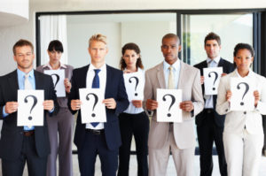 People holding question mark signs