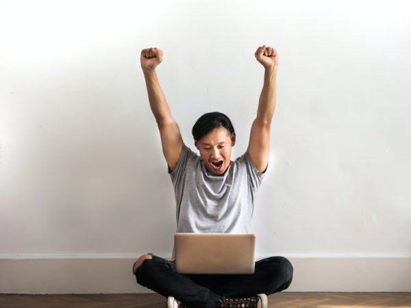 Man celebrating with laptop